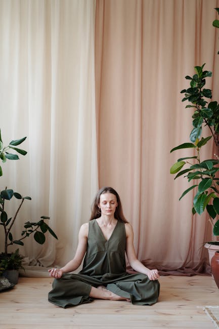 Woman sitting in a lotus pose with closed eyes, practicing breathing